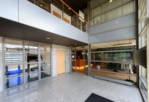 Ingang van een modern kantoorgebouw aan de Rivium 3e Straat met onder andere Van Waning en Tri Colore II.